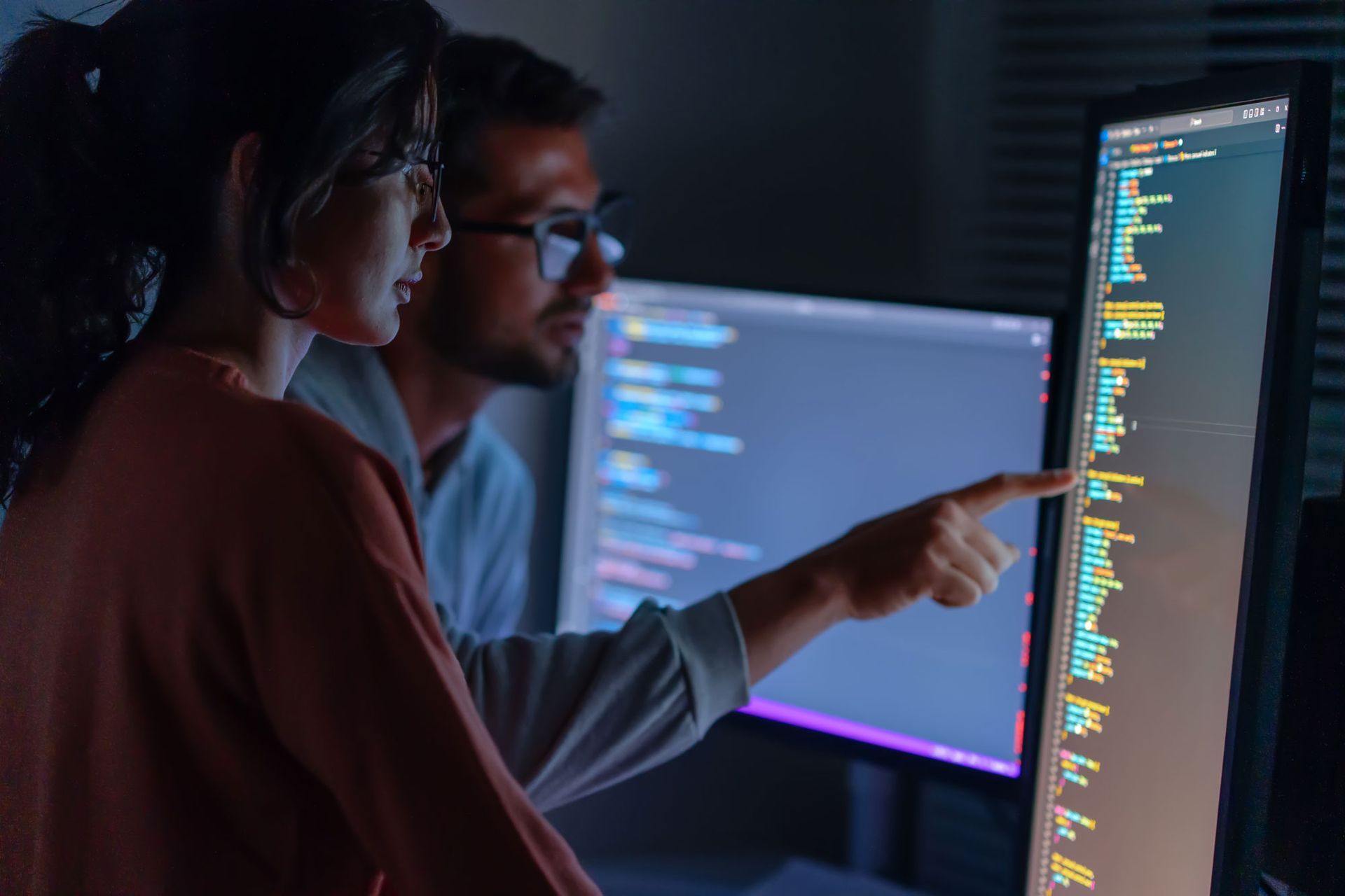 A man and a woman are looking at a computer screen.