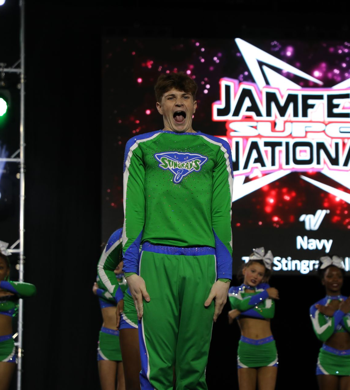 A cheerleader is making a heart shape with her hands.