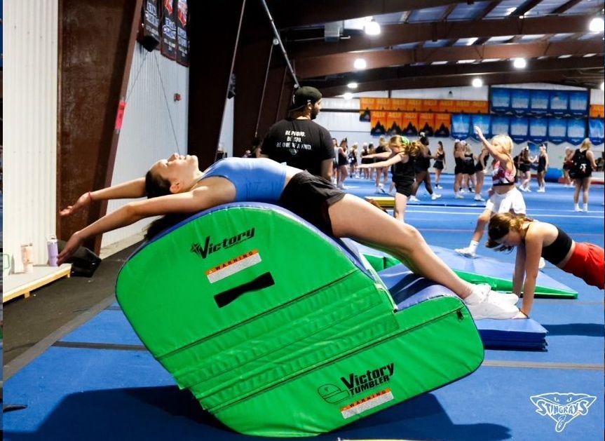 A group of girls are doing gymnastics in a gym.