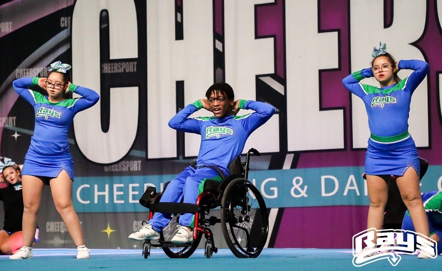 A cheerleader for the rays is raising her arms in the air