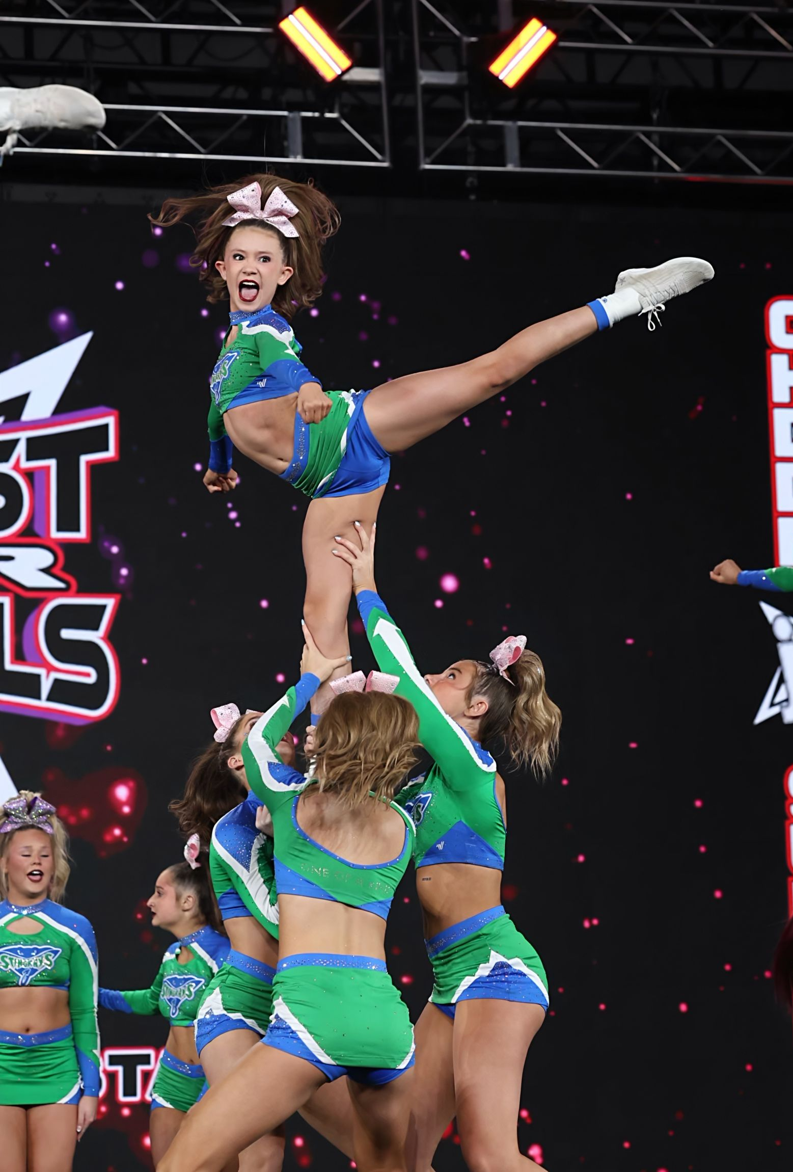 A group of cheerleaders are performing on a stage.