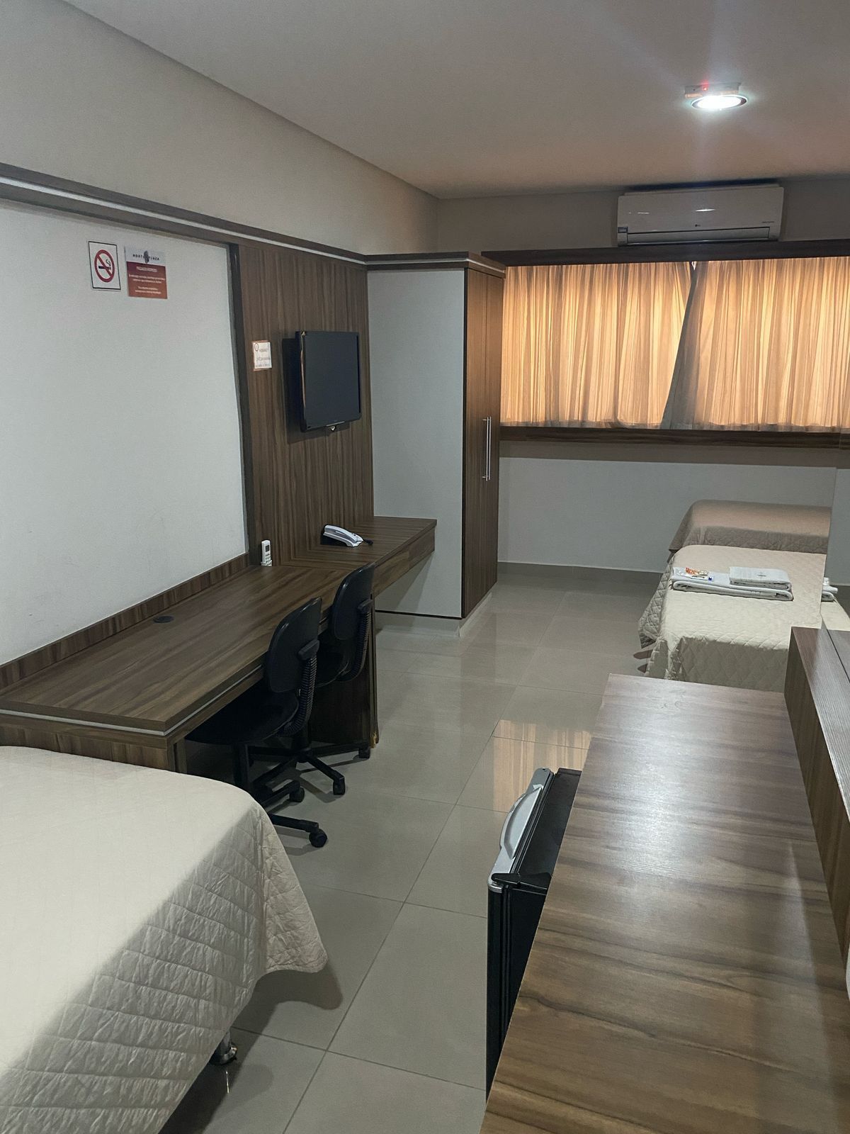 Um quarto de hotel com duas camas e uma escrivaninha