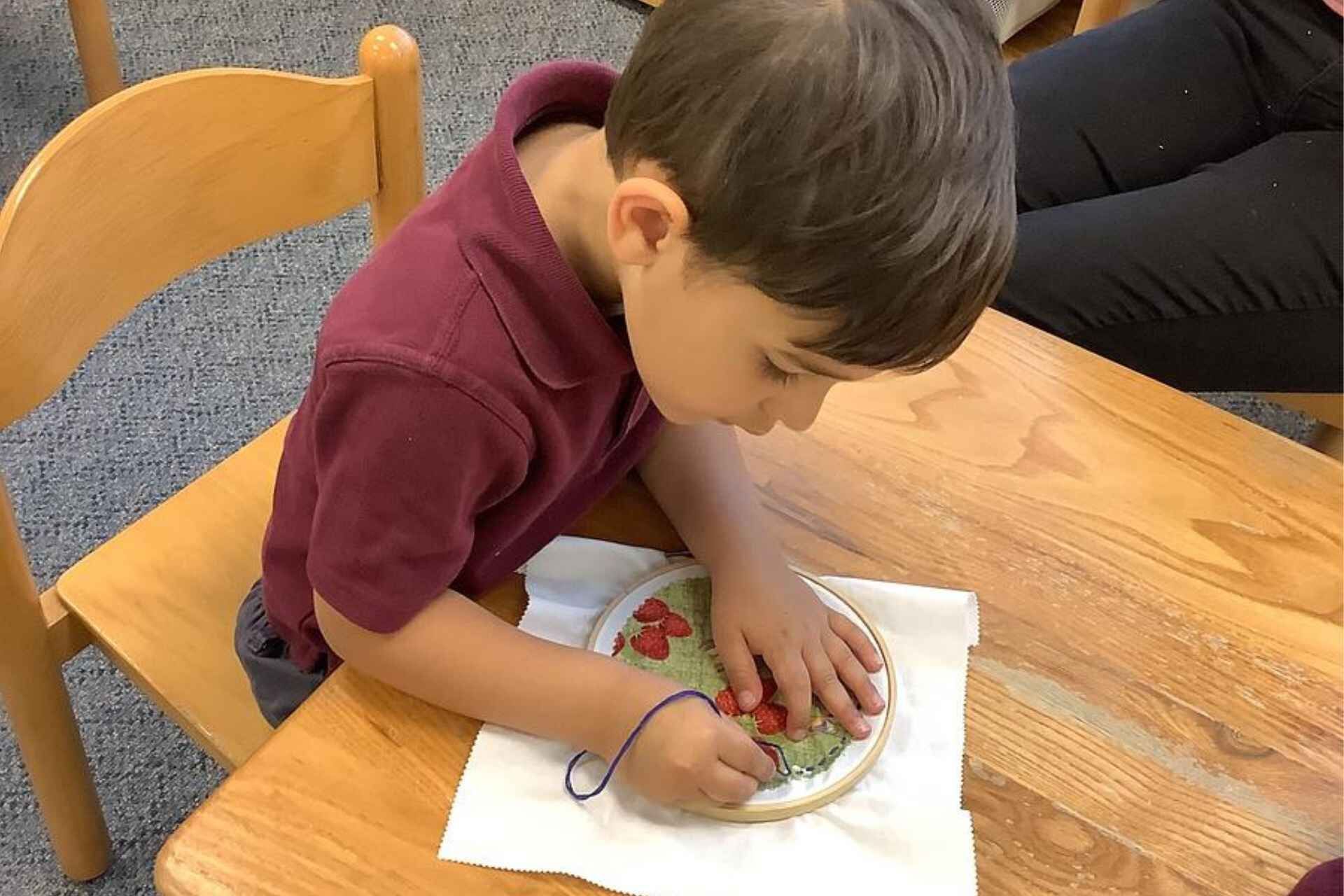 Montessori working with focus, showing persistence and independence in work.