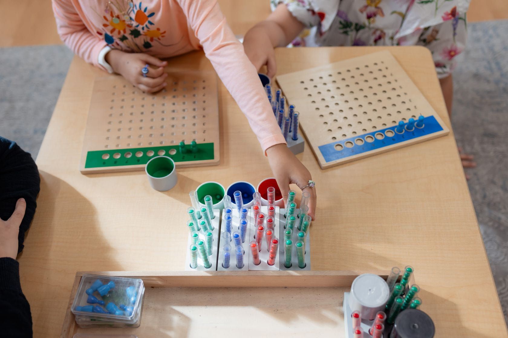 Children using Montessori racks and tubes to explore long division hands-on.