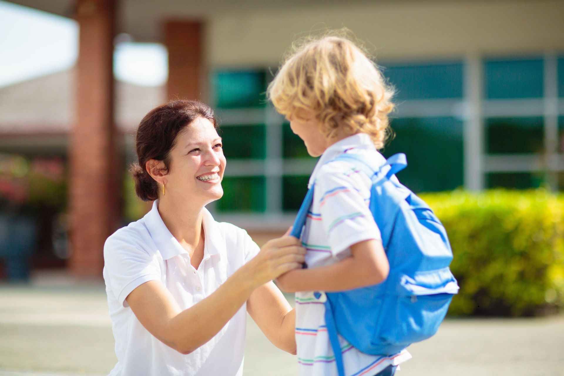 Adult warmly greets child after school, supporting calm transition and connection