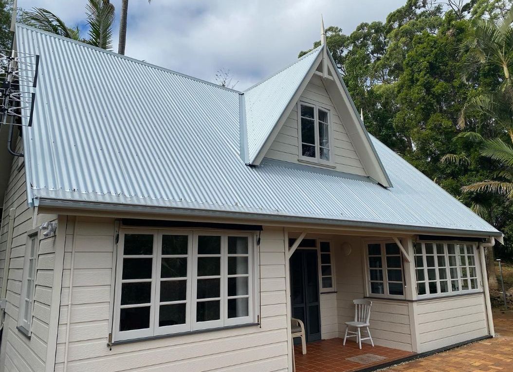 The exterior of a house with a blue metal roof.