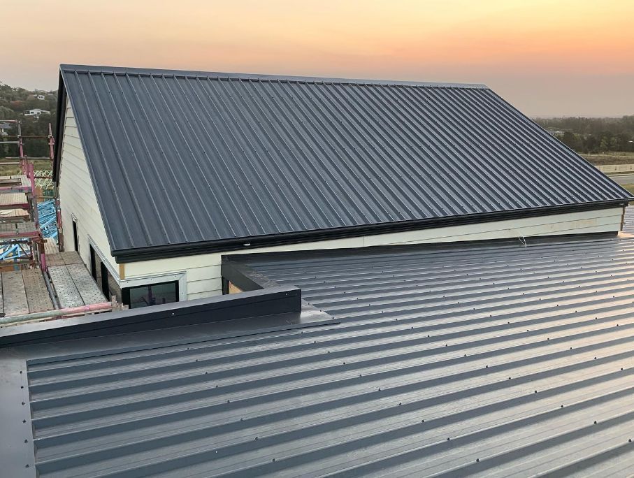 New metal roof installation on a residential build photographed at sunset.