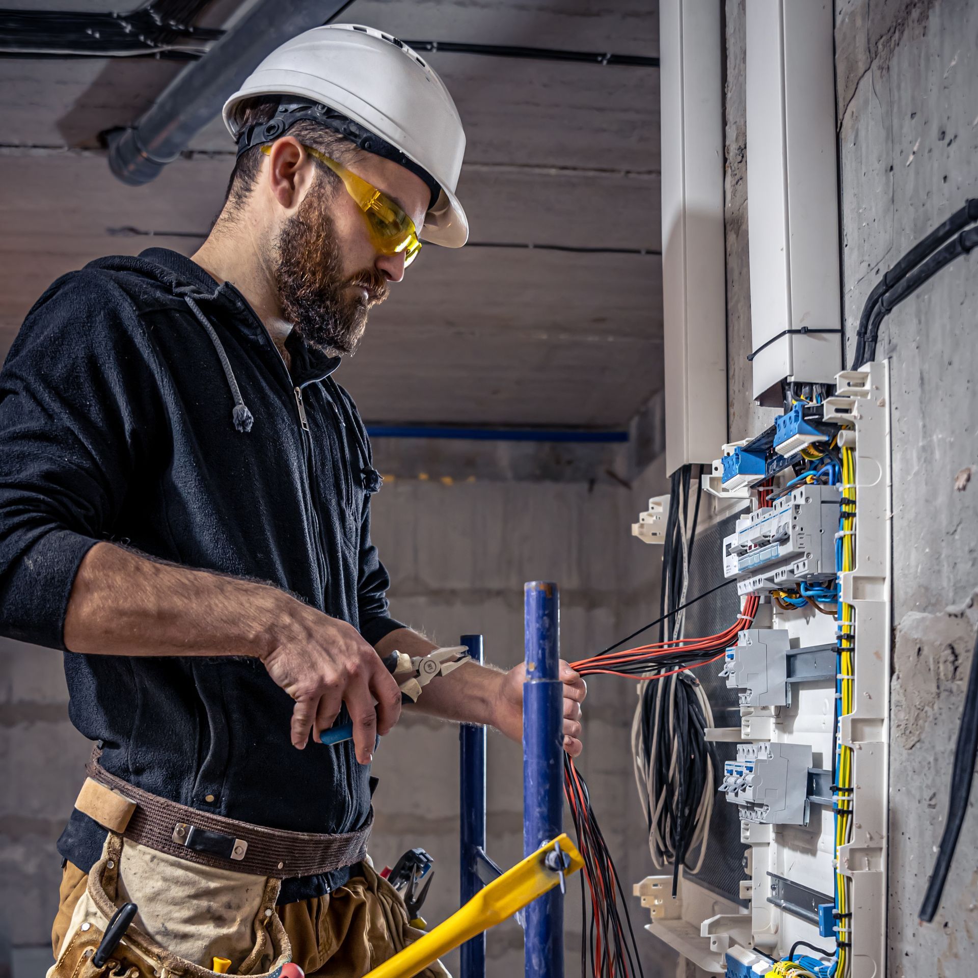 an electrician is working on a electrical box in a building .