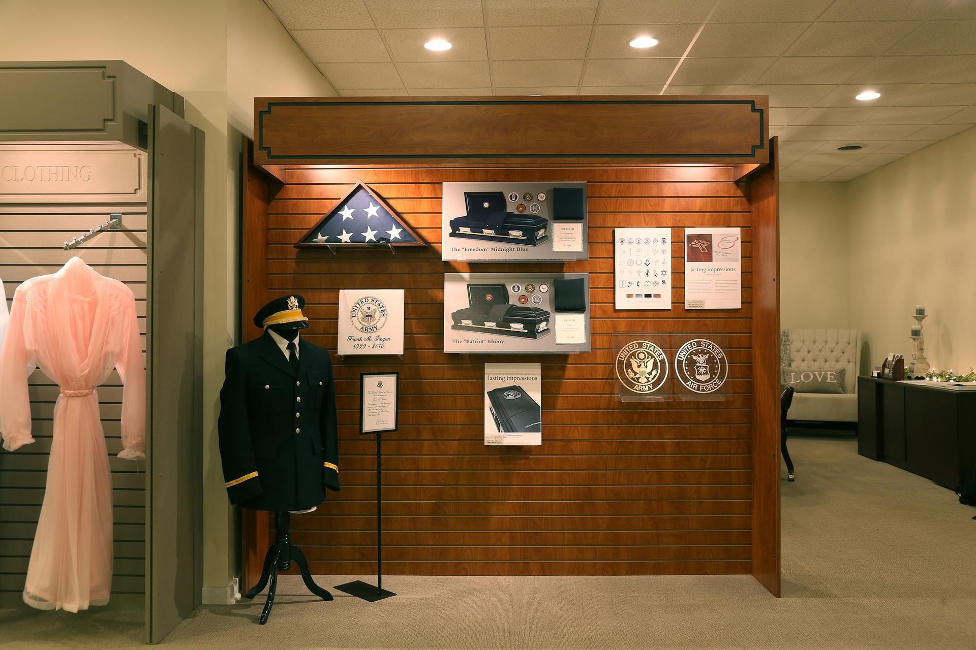 Museum exhibit wall with naval memorabilia and photos, beside a mannequin in a dark uniform