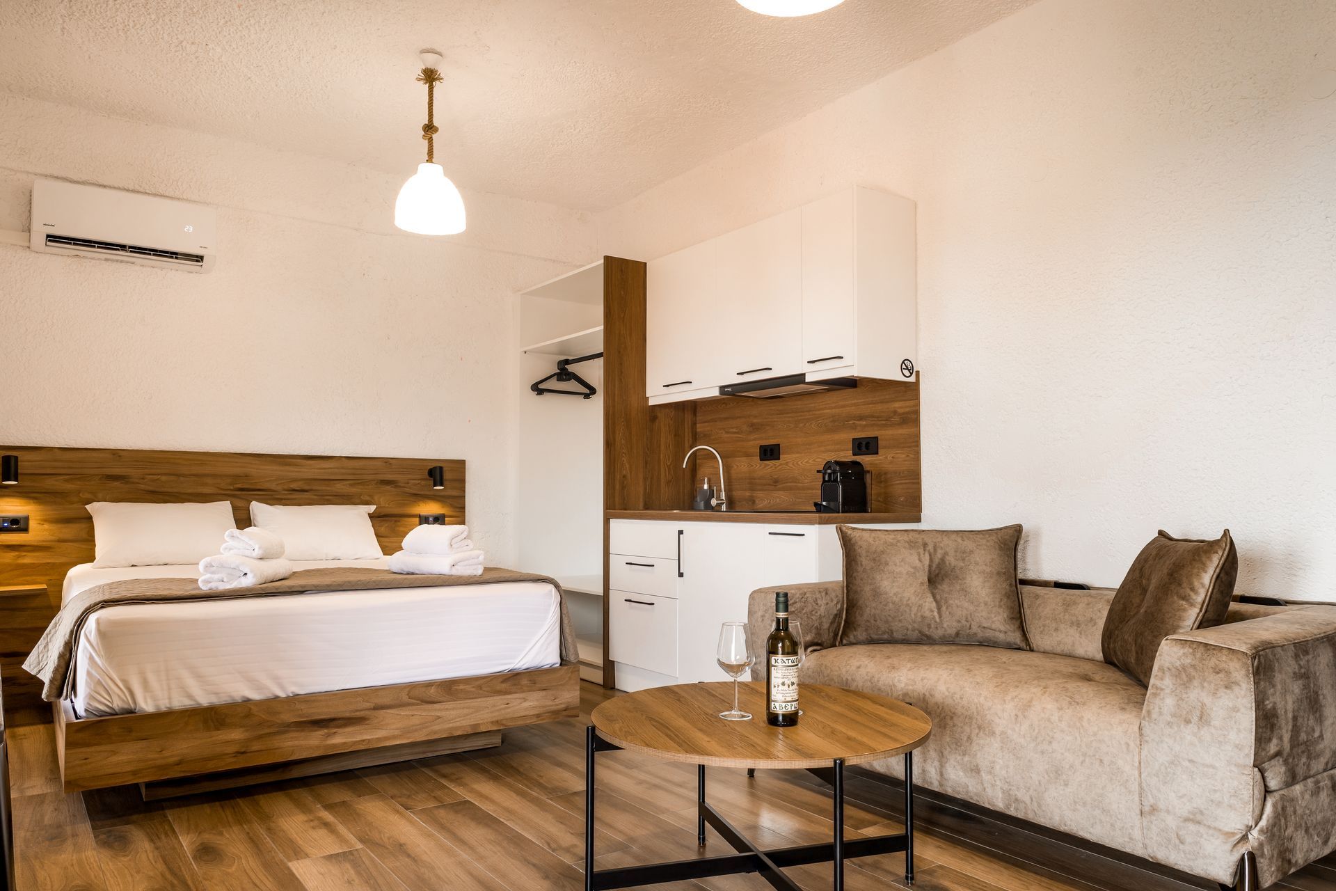 Modern bedroom with wooden bed, white linens, beige walls, and open closet nook