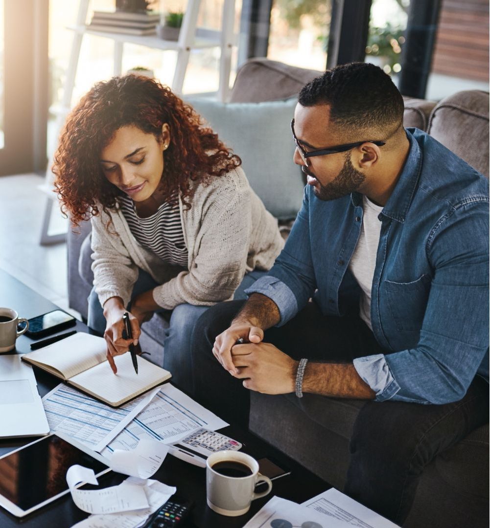 A man and a woman are sitting at a table looking at papers.