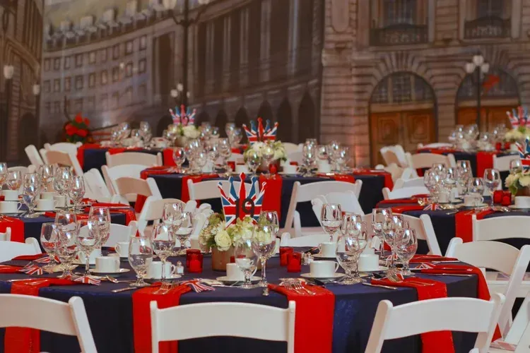 Elegant banquet hall with red, white, and black table settings and floral centerpieces