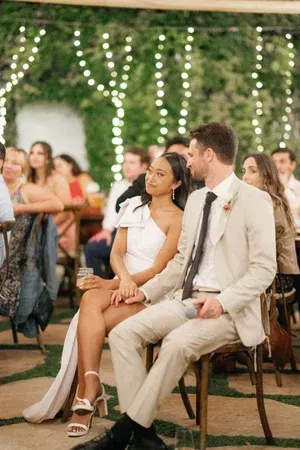 Guests seated at an outdoor wedding reception under string lights