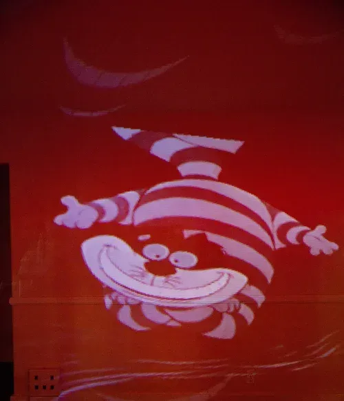 White cartoon cat grinning on a red background, with a striped body and one arm raised