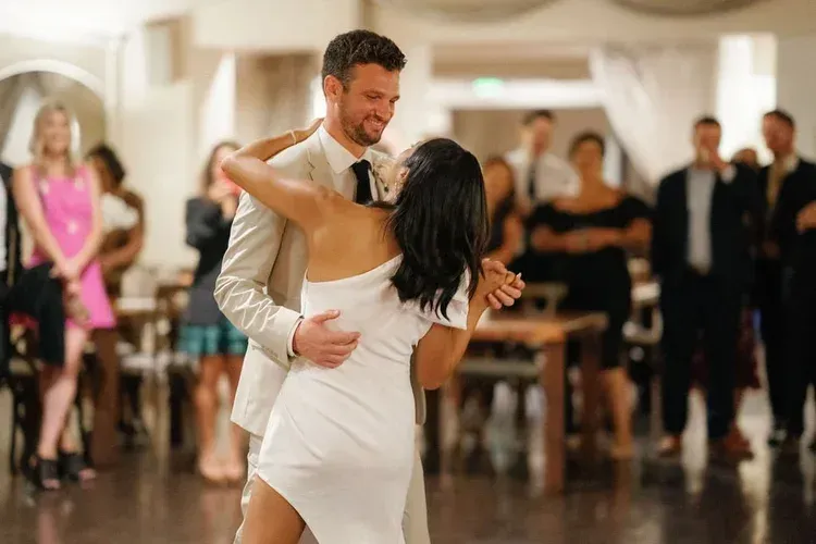 Couple dancing in a ballroom with guests watching in the background