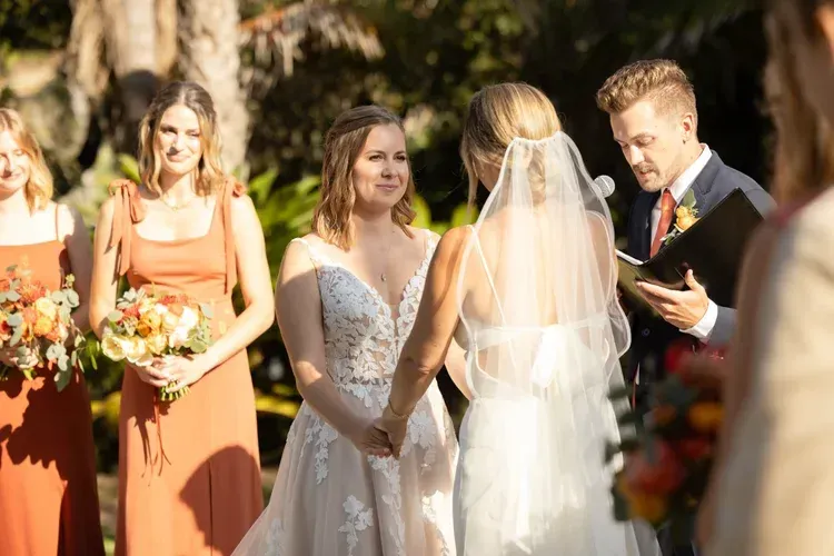 Wedding ceremony outdoors with bride and groom exchanging vows as bridesmaids stand nearby
