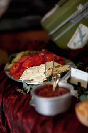 Assorted pastries and desserts on a table, including a cream-topped cake with strawberries and a bowl of jam