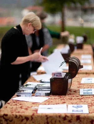 Person browses papers at an outdoor table with books and a vintage typewriter