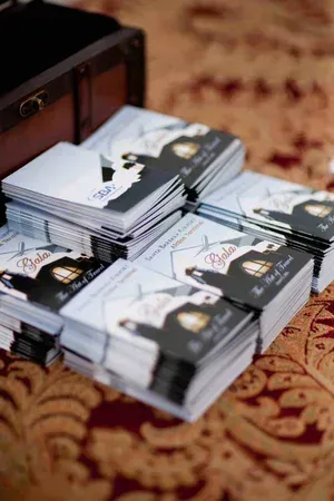 Stacks of black-and-white business cards in an open wooden box on a patterned carpet.