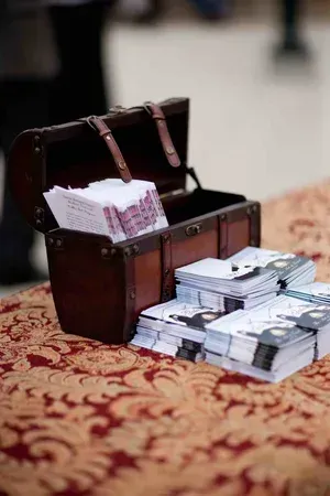 Open treasure chest filled with bundled cash on a patterned carpet