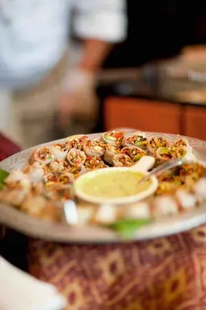 Plate of assorted appetizers with a central dipping sauce on a table at a restaurant