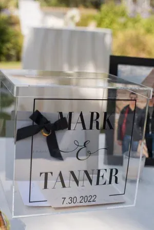 Clear acrylic card box with black ribbon, labeled “Mark & Tanner” and date 7.30.2022