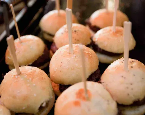 Skewered bite-sized dough balls dusted with seasoning on a tray