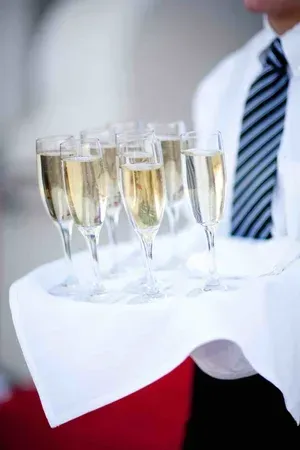 Waiter carrying tray with champagne flutes at a formal event