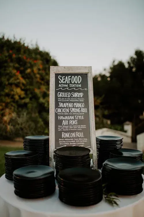 Seafood platter display with black plates and a chalkboard sign outdoors