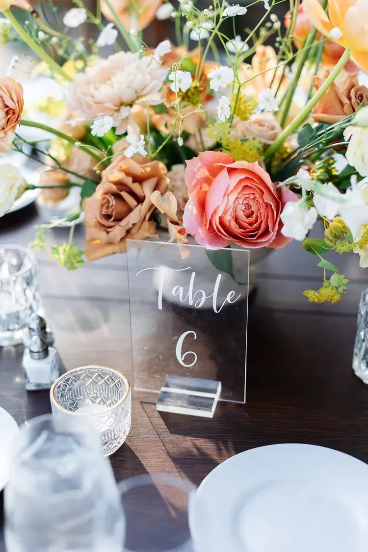 Floral centerpiece with table number 6 on a decorated reception table