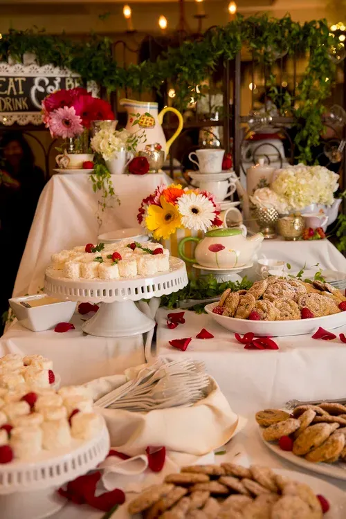 Elegant dessert buffet with cakes, pastries, and flowers on a decorated table