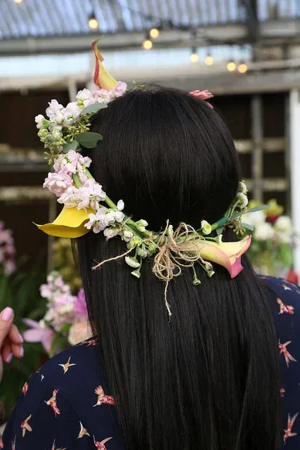 Back view of long black hair adorned with a floral crown and ribbon