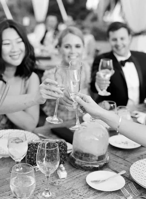 Friends toasting with champagne glasses at a candlelit dinner table