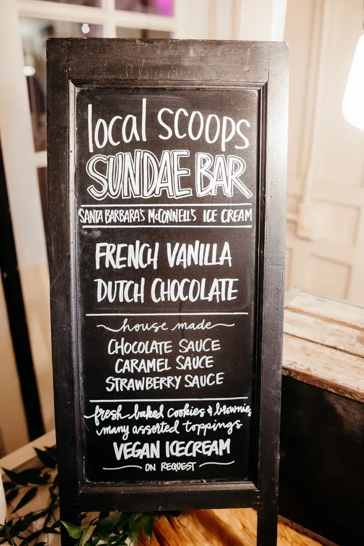 Chalkboard sign advertising local scoops, summer flavors, and vegan ice cream flavors like french vanilla and dutch chocolate