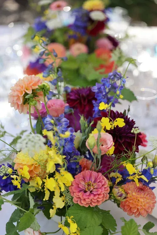 Colorful bouquet of mixed flowers in a vase, with pink, yellow, purple, and blue blooms