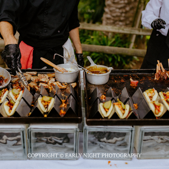 Street food skewers and bowls on display at an outdoor market stall