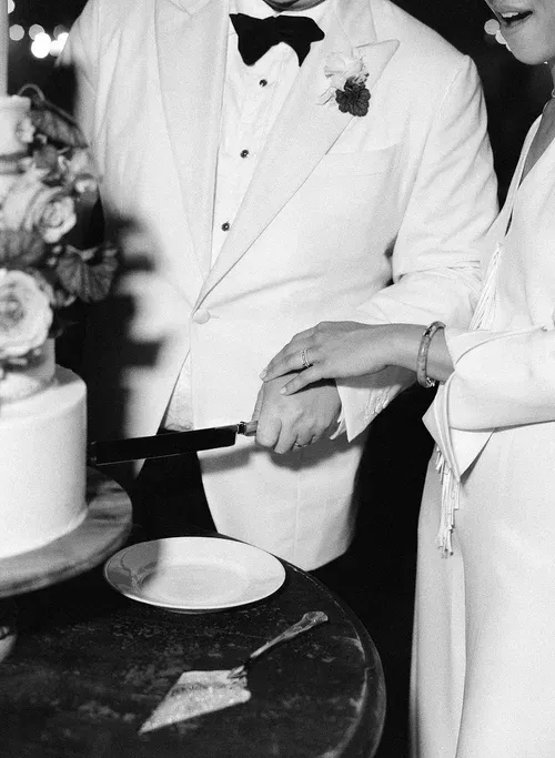 Bride and groom cutting a wedding cake with a knife on a decorated table