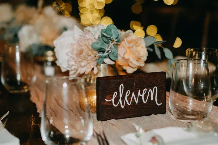Elegant table setting with a dark “eleven” place card, floral centerpiece, and glassware