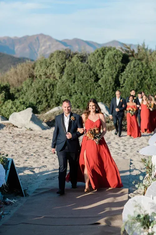 Wedding couple walking down an outdoor aisle with mountains in the background