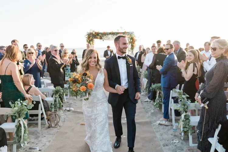 Newlywed couple walking down an outdoor aisle after their wedding ceremony
