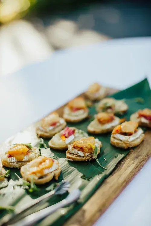 Assorted bite-sized appetizers on a wooden board at a catered event