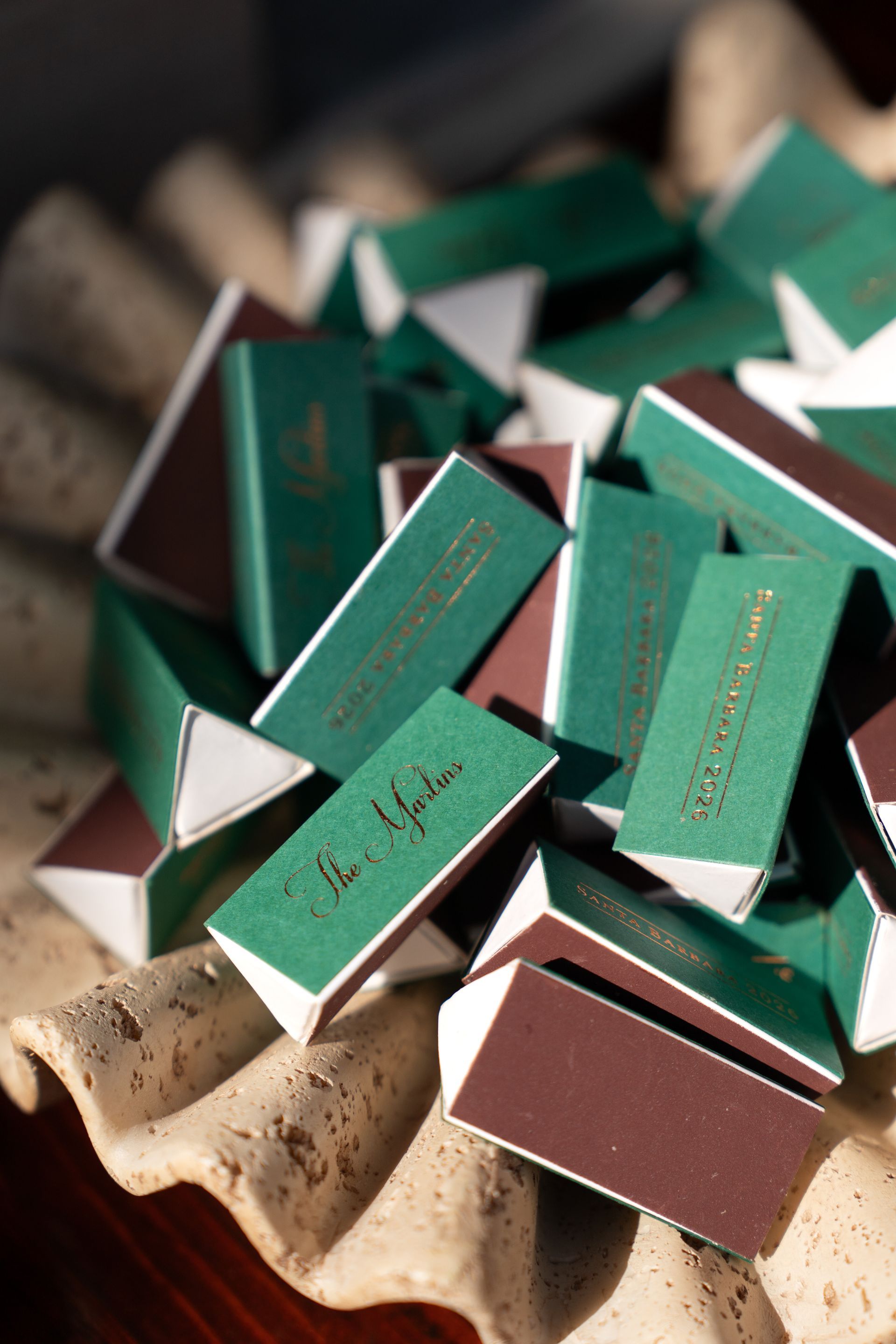 Stacked green and brown matchboxes on a beige tray