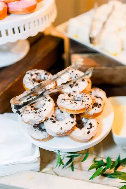 Dessert plate with powdered donuts and tongs on a buffet table