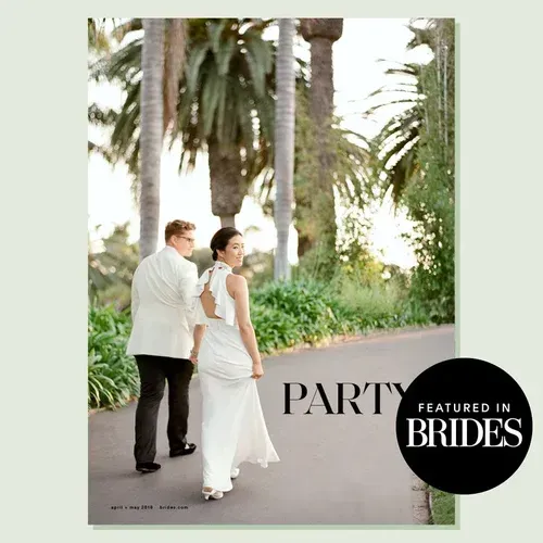 Wedding couple walking on a palm-lined path with “Party Featured in Brides” text