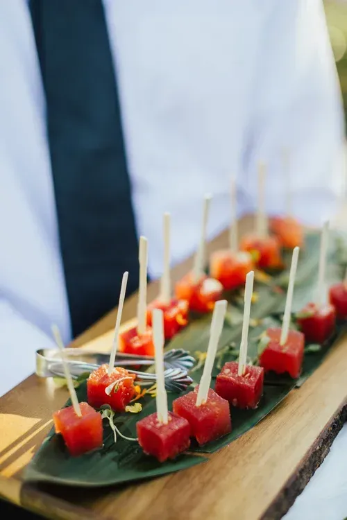 Assorted tomato and cheese skewers arranged on a black serving tray at a buffet