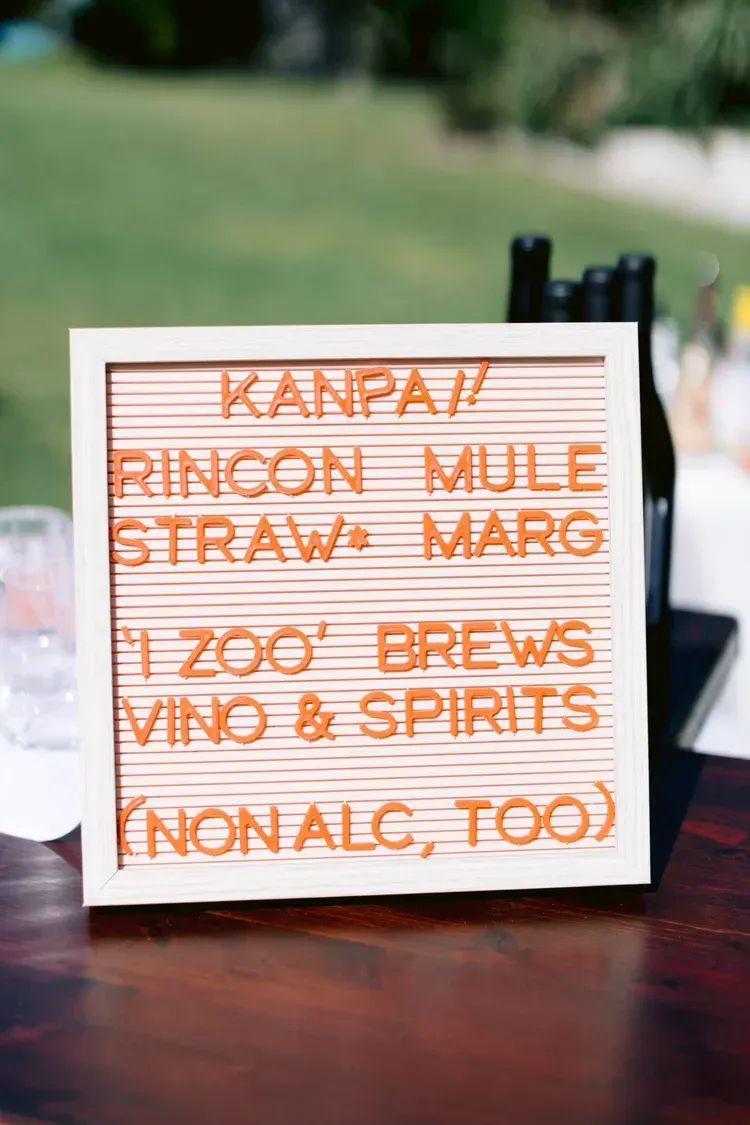 White sign listing drinks: Kanpai, Rincon Mule, straw, margarita, Zoo’s brews, wine & spirits, non-alc too