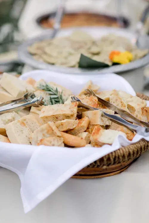 Assorted flatbreads and pastries in a wicker basket at a buffet table