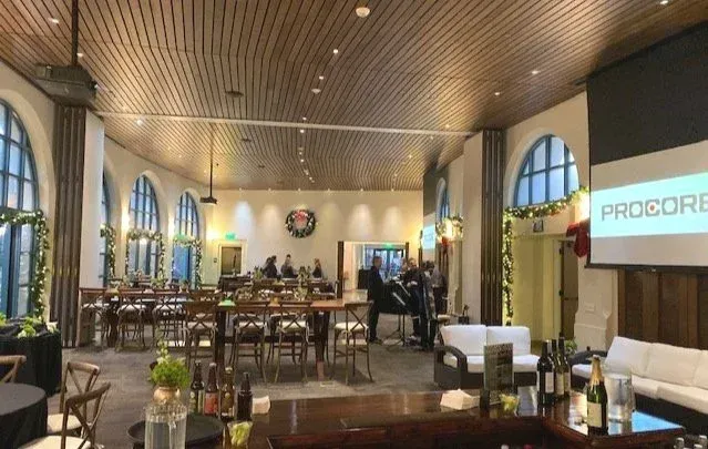 Elegant restaurant interior with arched windows, wooden ceiling, and set dining tables