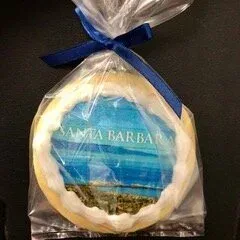 Blue-ribboned packaged cookie with Santa Barbara beach scene printed on top
