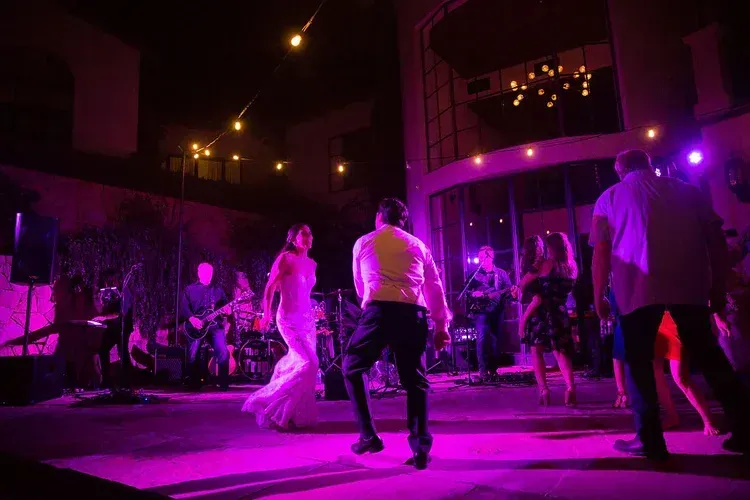 People dancing at a nightclub under vivid purple lighting